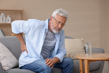 Senior man suffering from backache at home