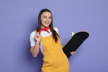 Smiling woman with skateboard on violet background