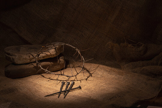 Crown of thorns and rosary beads on brown texture background with space for text