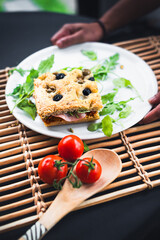 Italian sandwich made with focaccia bread, olives, ham, tomatoes 