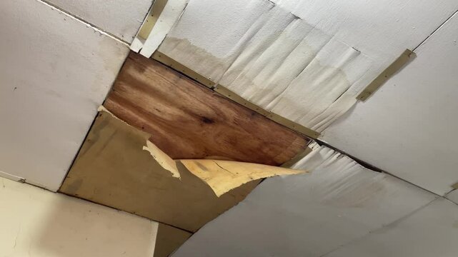 The house ceiling made of plywood peeled off due to rainwater. The house ceiling leaked.. House The plywood ceiling peeled off