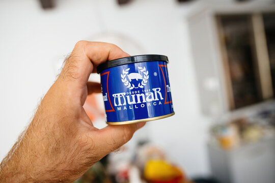 Haarlem, Netherlands - Sep 6, 2024: A hand holds a blue Munar Mallorca can, a traditional Spanish product, emphasizing authentic regional branding and cuisine