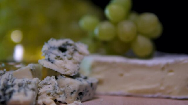 cheese white wine green grapes brie cheese with honey camera slowly moving black background. dorblu cheese