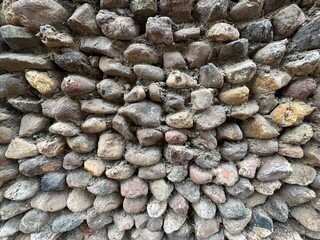 Stone deeply textured of wall background. Green grunge stone texture, pattern wallpaper and background. Natural contrast wall rock granite with colorful stones. Cement between stones. Perfect texture.