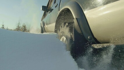 A truck and car navigate a snowy road in harsh winter conditions