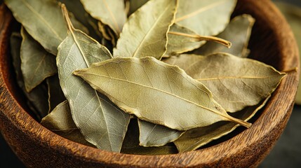 Dried bay leaves in a wooden bowl on a rustic table