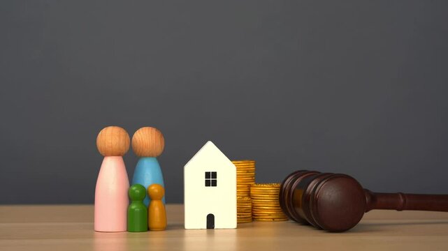 A woman places a judge's gavel near houses with family and coins. Real estate court decisions. Property inheritance litigation. Establishment of ownership. Amnesty for violations of construction rules