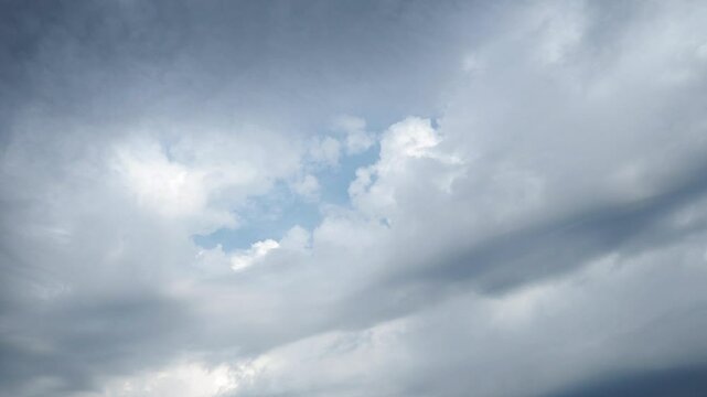 Beautiful white and dark storm clouds in blue sky. Volumetric effect. Convection in troposphere. Real time. Cumulus clouds low-level, puffy, cotton-like. Fluffy Cumulonimbus. Rainy terrible clouds