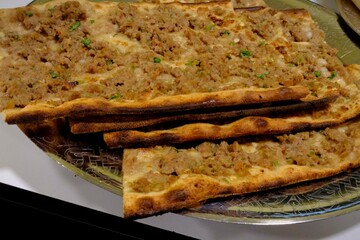 Close-up photo of traditional taste of Turkish cuisine, Konya meat bread, on copper plates. It is served with frothy buttermilk and pickles. Food industry, restaurant food. Types of pita bread.