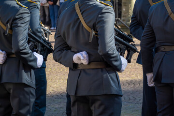 Italian soldiers standing in formation, wearing uniforms, holding weapons during a ceremonial event outdoors.