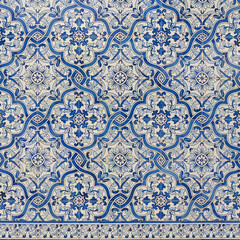 Fragment of building wall with colorful ceramic wall tiles. Azulejo close up. Abstract decorative background, textured ornate pattern for design or backdrop. Traditional ornate Portuguese architecture