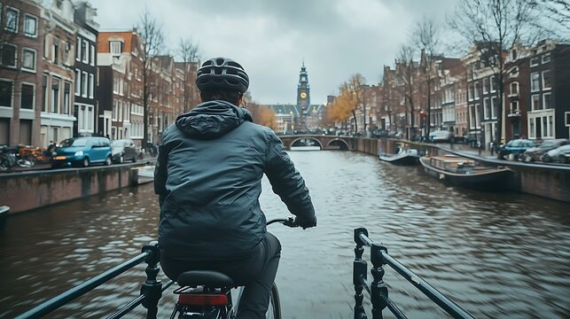 A man is riding a bicycle on a bridge over a river