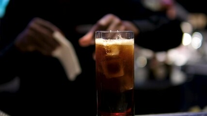 whiskey cola african american bartender serves glass with drink cold. bar in luxury restaurant rest relaxation party