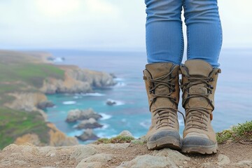 Person Standing on a Cliff Near the Ocean, Wearing Hiking Boots, Surrounded by Nature and Scenic Coastal Landscape with Waves and Rocks