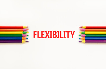 Flexibility symbol. Concept word Flexibility on beautiful white paper. Beautiful white paper background. Beautiful colored pencils. Business flexibility concept. Copy space.