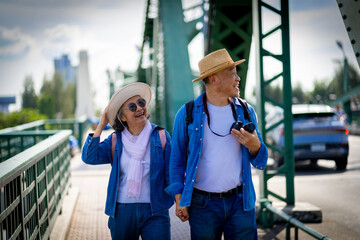 Asian retired couple happily hang out together in city full buildings in capital Thailand Bangkok