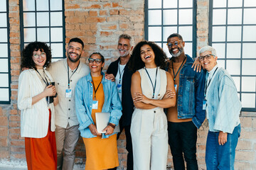 Diverse and happy small business team posing together in a sleek and modern office environment