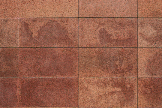 Granite tile wall, bricks, memorial cladding. Even rectangular red blocks, background. smooth surface of treated natural stone.