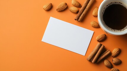 Elegant mockup of blank business cards surrounded by almonds, cinnamon, and a cup of coffee on a vibrant orange background for creative branding.