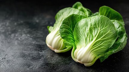 Fresh Bok Choy or Pak Choi with vibrant green leaves displayed on a dark textured background for culinary and health-related imagery.