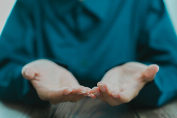 Open hands in blue shirt, symbolizing offering or sharing. gesture conveys openness and willingness...