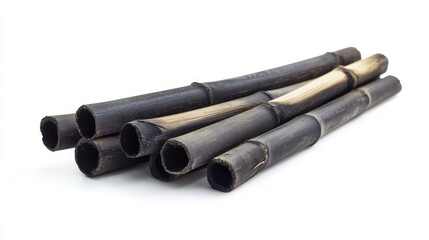Fototapeta premium Bamboo charcoal sticks arranged on a white background showcasing their natural texture and unique appearance for various applications