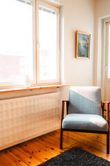 Cozy Living Room Corner with Mid-Century Modern Armchair by Sunlit Window and Elegant Wall Art in Stylish Urban Apartment Interior