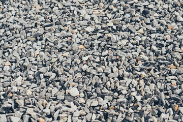 Gravel texture with small stones in various shades of gray and brown. Ideal for construction, landscaping, or decorative purposes