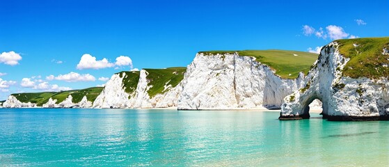 Stunning white chalk cliffs with turquoise ocean waters under clear blue sky