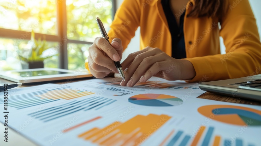 Poster Team members engage in a focused discussion while examining charts and graphs on a table. The atmosphere is filled with creativity and insight as they prepare for an important presentation