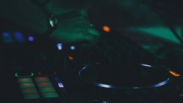 DJ work in a nightclub, mixing. A club DJ mixes music using an audio mixer and turntables on stage. A disc jockey plays in a club at a party.