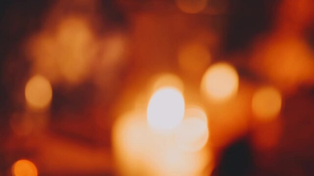A blurred picture of candles burning on the dinner table