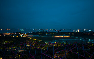 Illuminated skyline of Singapore and the busy shipping lanes during the blue hour