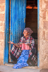 single motswana african woman in the village wearing traditional setswana clothes in front of her...