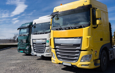 3 colorful cabs parked in a row on a sunny day in a parking lot. . Commercial vehicles, advertising of vehicles for business cargo transportation. Industrial machines for leasing