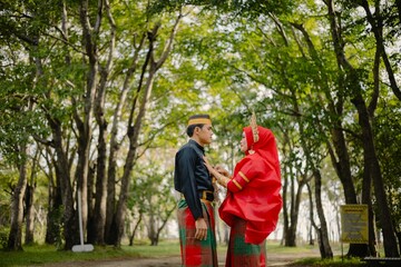 Portrait of Asian Men and Women wearing traditional Bugis clothes posing for pre-wedding