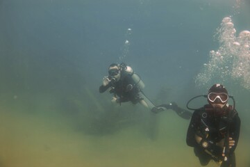 Divers exploring muddy waters with scuba gear