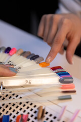 Nail choosing nail polish color from color palette in beauty salon, nail color palette