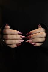 Beautiful female hand with red prosthetic nails, heart design