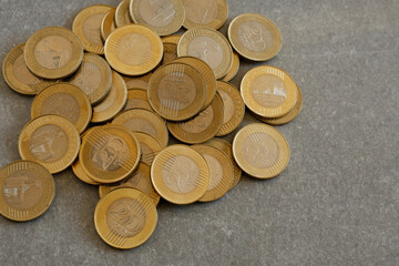 Close-up of gold coins on a grey surface.