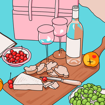 Charcuterie board with wine glasses on a picnic blanket