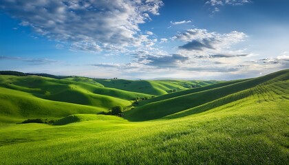 Obraz premium Lush green hills under a bright blue sky.