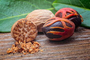 Nutmeg (Myristica fragrans), Myristicaceae. Spice, fresh nut with mace. On wooden table.