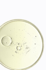 The texture of a cosmetic serum or body gel in a Petri dish.