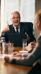 Senior manager gesturing while explaining concept during business meeting with colleagues, engaging team in discussion. Concept of business, collaboration, leadership, strategy, brainstorming