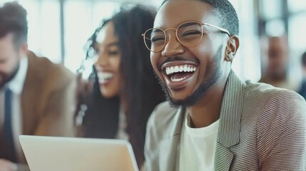 Obraz premium A diverse group of business professionals gathers in a bright, modern workspace, sharing laughter and smiles as they engage in a lively discussion, fostering creativity and collaboration