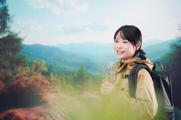 Naklejka premium 登山をしながら水分補給をする若い女性