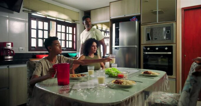 Family enjoying lunch together at dining table in cozy kitchen, featuring natural connection, wholesome lifestyle, and shared moments of daily life