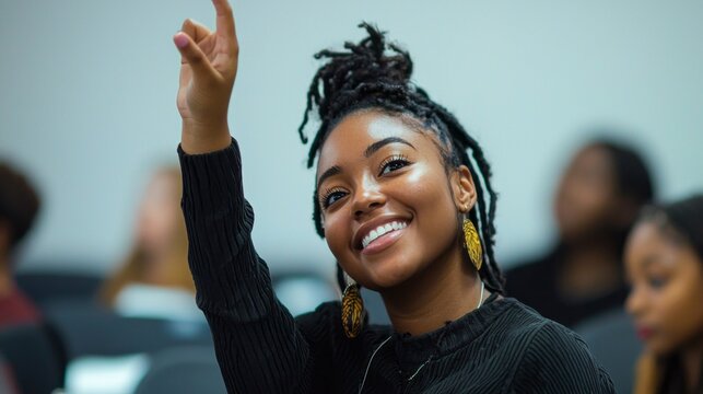 A cheerful African American student with beautiful hair expresses enthusiasm by raising her hand in a classroom setting. The bright atmosphere encourages active participation and learning