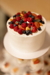 ripe red berries strawberries and raspberries on white wedding cake	